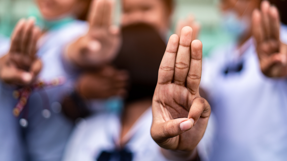 Students,Girl,Showing,Three,Finger,Salute,In,School.16:9,Style